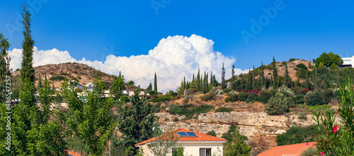 The picturesque Mediterranean landscape of the village of Pissouri: white houses with orange roofs are scattered across the mountainous area of Cyprus photo