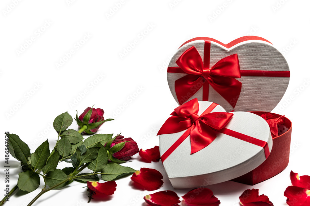 2 heart shaped gift boxes and 2 red roses on a white background with copy space.
2 heart shaped gift boxes and 2 red roses on a white background with copy space.