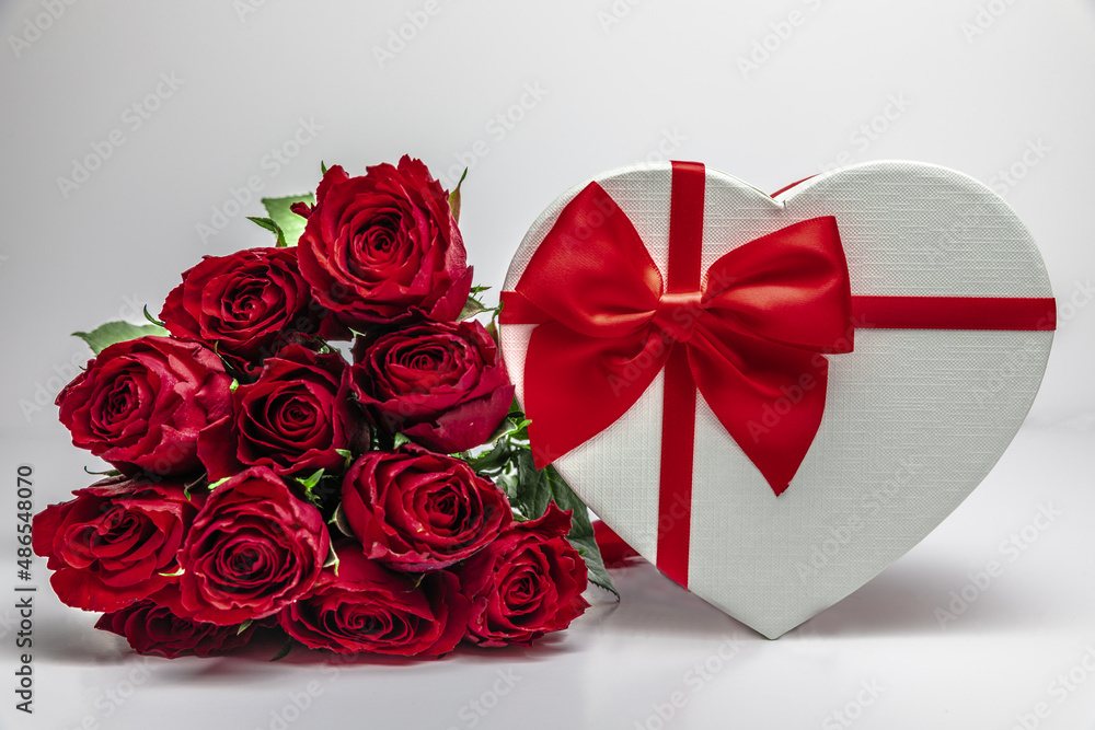12 red roses and a gift box on a white background. copy space 12 red roses and a gift box on a white background. copy space