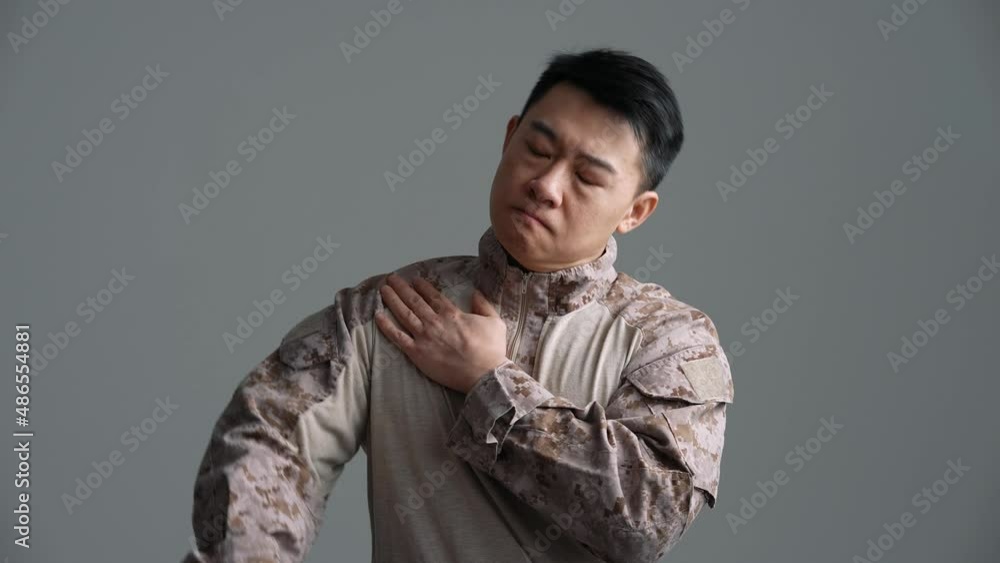 Confident soldier Asian man warming up in the grey studio Confident soldier Asian man warming up in the grey studio