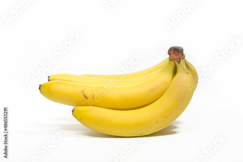 Bunches of yellow bananas lie on a white background, isolated