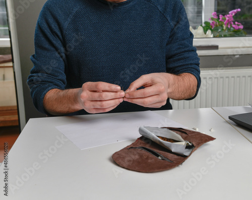 Male hand rolling cigarette    photo