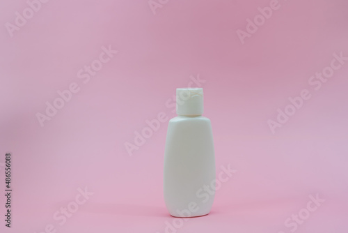 White plastic tube on pink background.   osmetic bottles for beauty or medicine products
