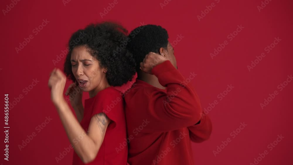 Cheerful African couple dancing in the red studio Cheerful African couple dancing in the red studio