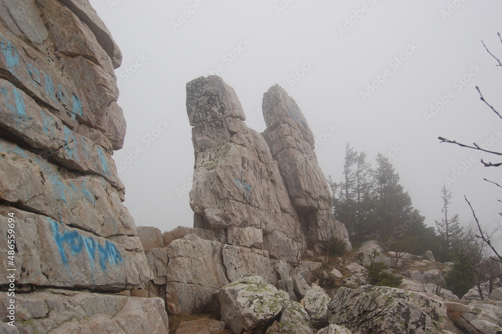 Rocks Devil's Gate, they are also stone gates on top of Mount Yurma, on top of the Yurminsky Range. Mountain spring landscape in the fog