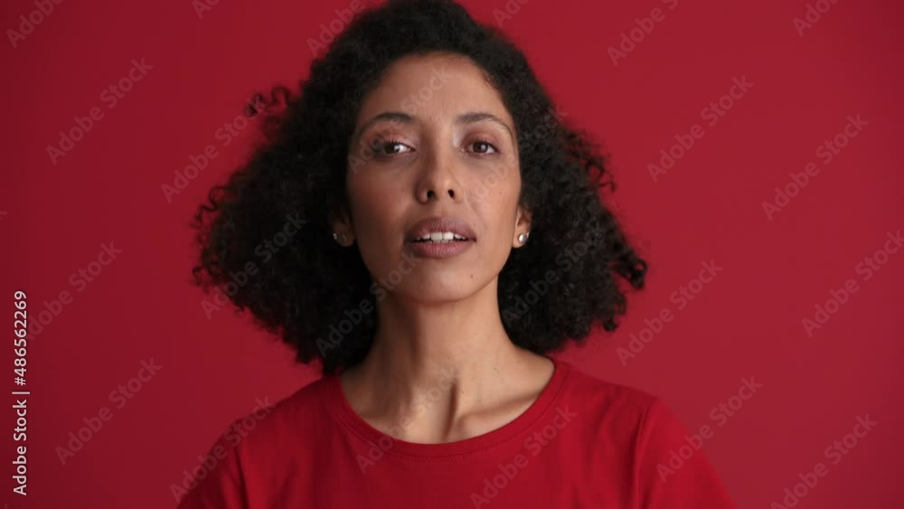 Smiling African woman positively shaking head in the red studio Smiling African woman positively shaking head in the red studio