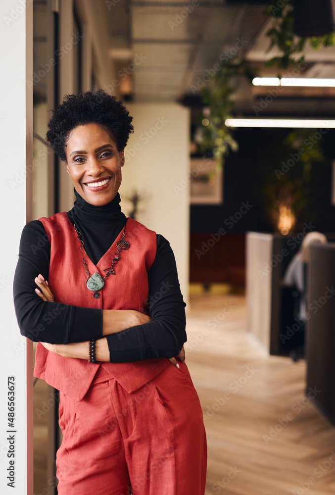 Fototapeta premium Portrait of confident mature black woman smiling and looking at camera in office space