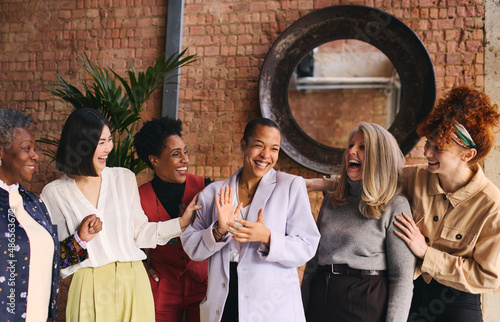 International Women\'s Day portrait of cheerful multi ethnic mixed age range businesswomen celebrating