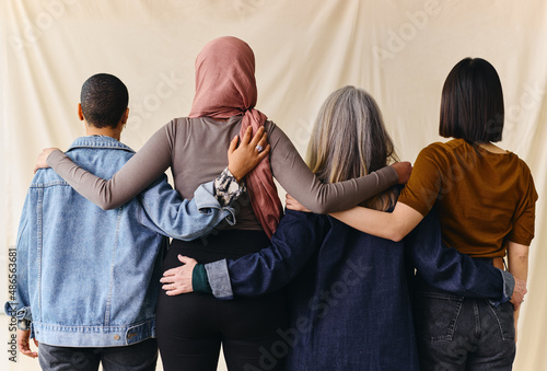 Εκτύπωση καμβά Rear view of four women with arms around each other in support of International