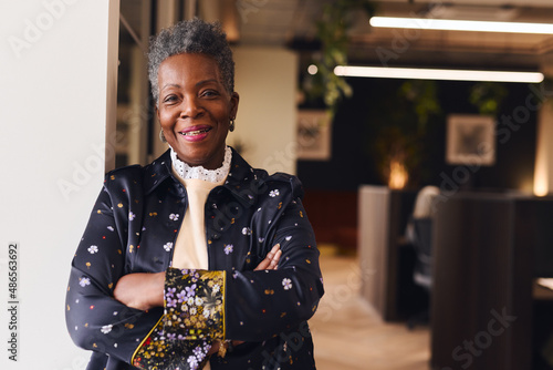 Portrait of confident senior black woman smiling and looking at camera with arms folded