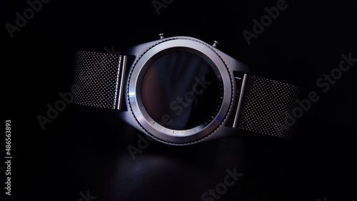 Silver elegant smart watch with a metal bracelet in the dark abstraction