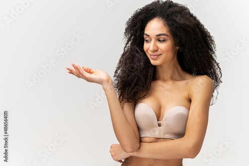 Woman portrait. Beautiful spa girl showing empty copy space on the open hand palm for text. Proposing a product. Skin care concept