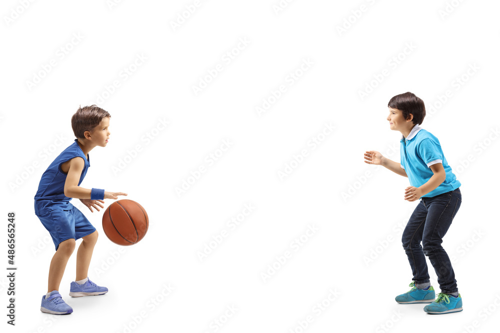 Full length profile shot of two boys playing basketball