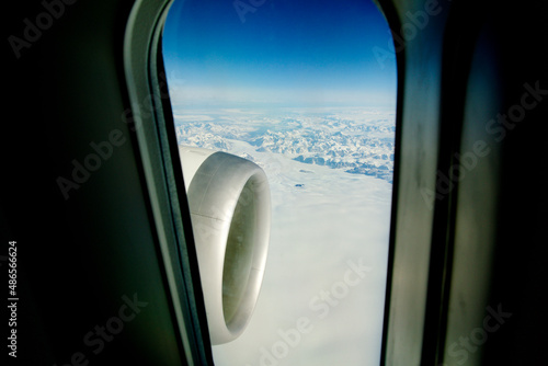 GREENLAND - 10 MAY 2018: View from the large plane window of a modern aircraft of the jet engine and the icy landscape of Greenland in the background