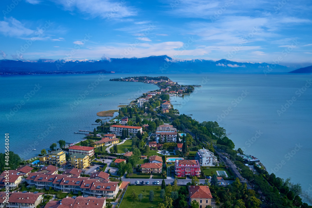 Sirmione at high altitude, Lake Garda, Italy. Drone view of Sirmione peninsula at sunrise. Sirmione, Lake Garda, Italy aerial view. Sirmione on Lake Garda drone view.