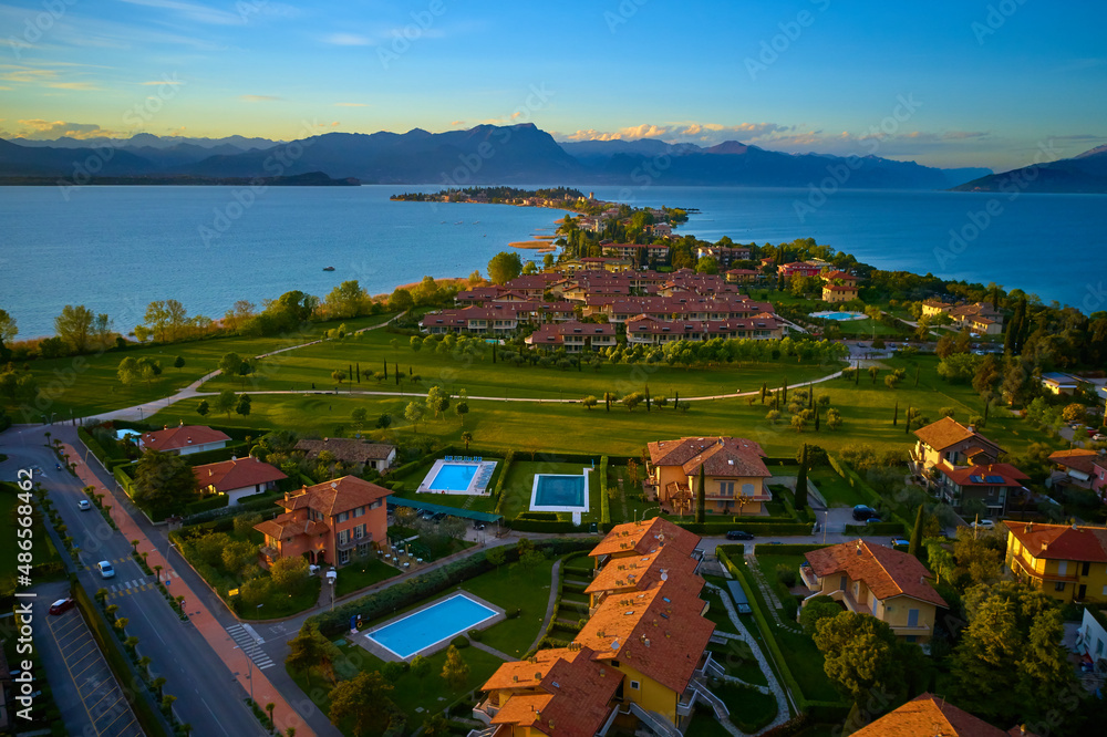 Drone view of Sirmione at sunrise. Sirmione Lake Garda Italy aerial view. Aerial panorama of Sirmione. Sirmione on Lake Garda drone view. Panorama of Lake Garda. Sirmione, Lake Garda, Italy.