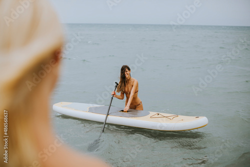 Two young women with paddle...