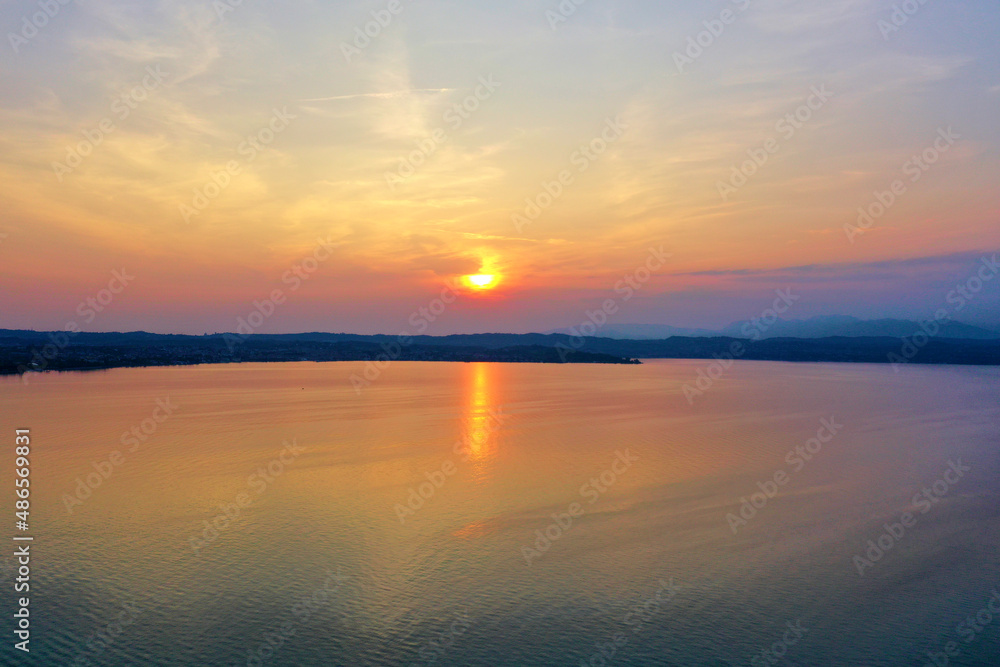 Sunrise over Lake Garda. Reflection of the morning sun in the water.