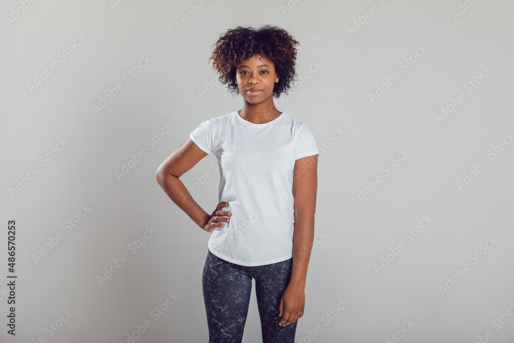 African american woman with puffy hair in a white t-shirt on a white background. Mock-up. African american woman with puffy hair in a white t-shirt on a white background. Mock-up.