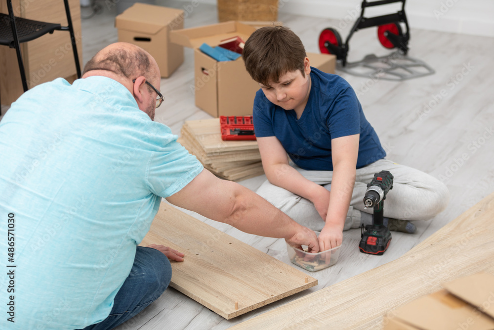 The father shows his son what and where to put the screws. The father shows his son what and where to put the screws.