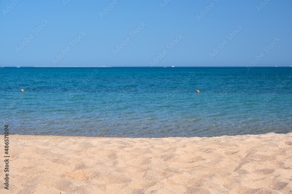 Seascape with surface of blue sea water with small ripple waves crashing on yellow sandy beach. Travel and vacations concept Seascape with surface of blue sea water with small ripple waves crashing on yellow sandy beach. Travel and vacations concept