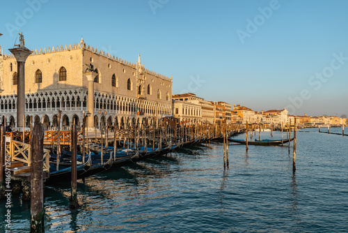 Venice,Italy.Embankment and famous Doges Palace on sunny day,canal and gondolas.Venetian city lifestyle.Architecture and landmark of Venezia.Popular tourist destination.Water transport,old houses