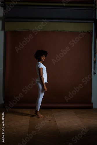Fototapeta Naklejka Na Ścianę i Meble -  African American girl in a white T-shirt and leggings. Mock-up.