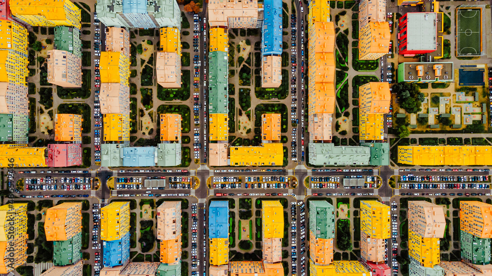 Flying above city buildings. Colourful development of the city. Modern architecture with houses and parkings Flying above city buildings. Colourful development of the city. Modern architecture with houses and parkings