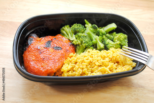A Meal of a Chicken Thigh with Catalina Dressing Baked on Top, Yellow Rice and Steamed Broccoli