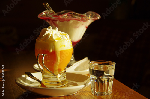 Yellow egg liqueur with whipped cream and a glass of water