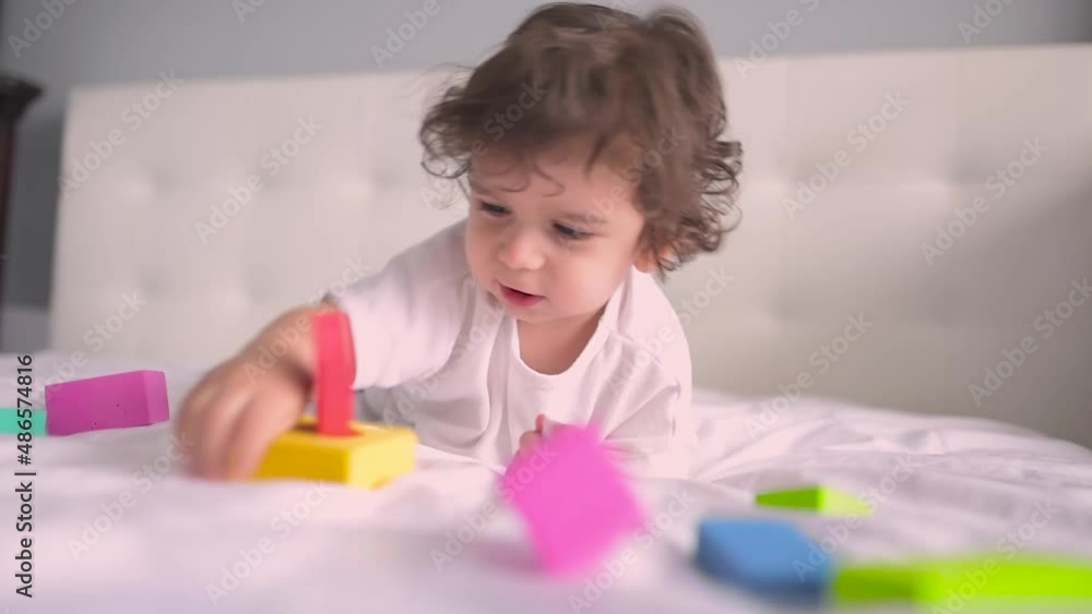 Happy little kid playing with colorful blocks at home. Learn through playing activity. Education for early development. Happy little kid playing with colorful blocks at home. Learn through playing activity. Education for early development.