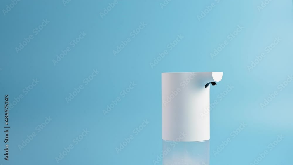 Hands of young woman press the touch button of an automatic soap dispenser on blue background. Concept of hand washing, hygiene, health, virus and bacteria protect. Turn on the soap dispenser Hands of young woman press the touch button of an automatic soap dispenser on blue background. Concept of hand washing, hygiene, health, virus and bacteria protect. Turn on the soap dispenser