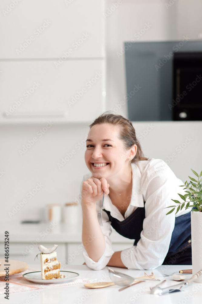 A woman confectioner in a blue apron is eating a piece of chocolate cake. Tasting delicious chocolate cake. High quality photo A woman confectioner in a blue apron is eating a piece of chocolate cake. Tasting delicious chocolate cake. High quality photo