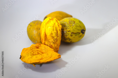a group of ripe yellow egg fruit or canistel (commonly known as the cupcake fruit, Pouteria campechiana, Sawo mentega, sawo ubi, sawo belanda, alkesah) isolated on white background. photo