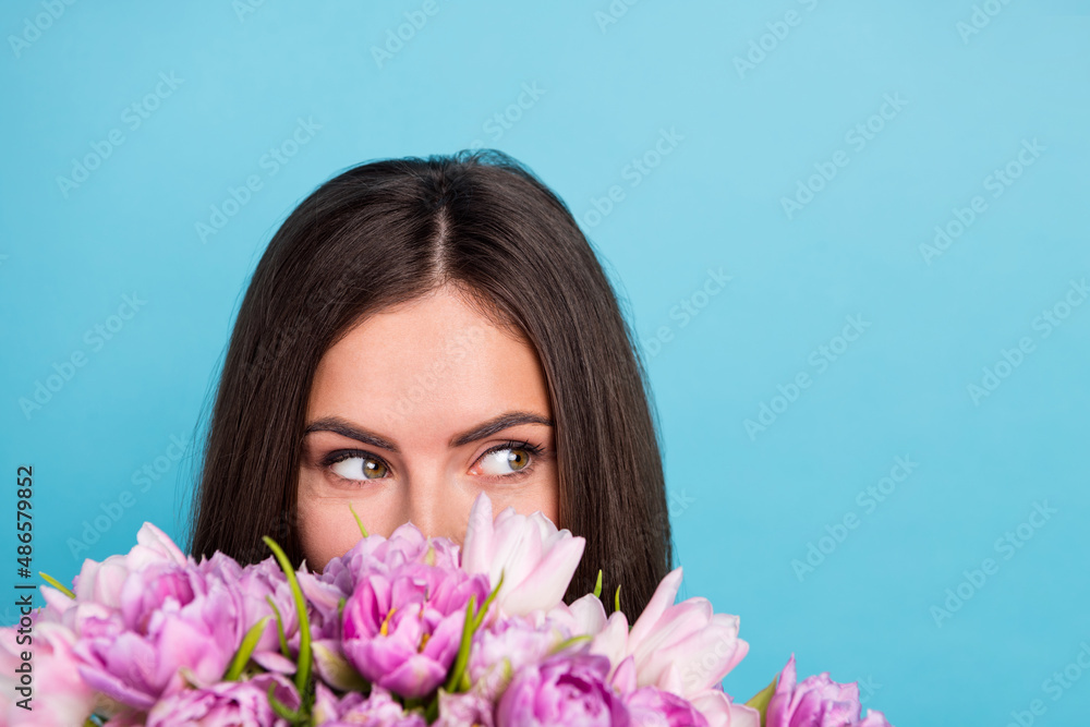 Cropped closeup image of adorable lady smell enjoy flowers scent look empty space dreaming isolated on blue color background Cropped closeup image of adorable lady smell enjoy flowers scent look empty space dreaming isolated on blue color background