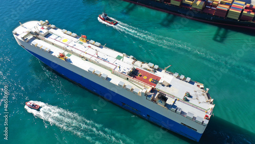 Aerial drone photo of large car carrier ro ro vessel guided by tug boats to anchor to Mediterranean car terminal port © aerial-drone