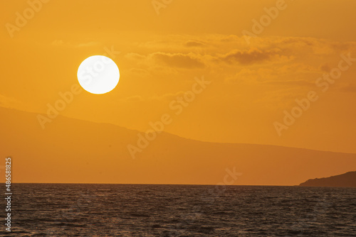 Magical golden sunset from Maui beach, sea and mountain background. 