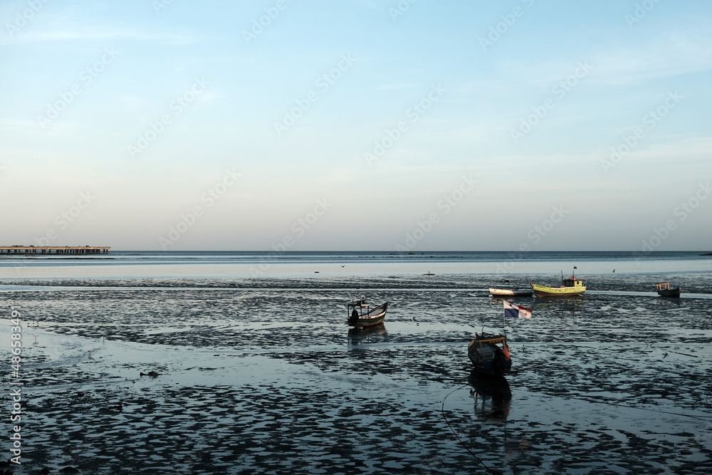 Small fishing boats reflected in the low tide