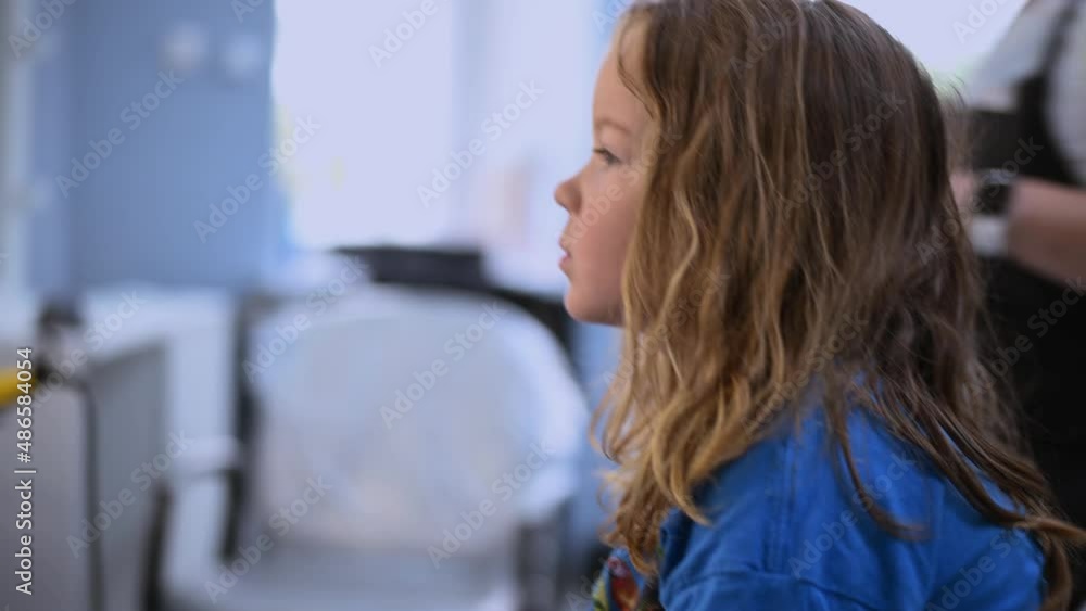 cute little girl getting her hair cut in a beauty salon close-up. High quality 4k footage cute little girl getting her hair cut in a beauty salon close-up. High quality 4k footage