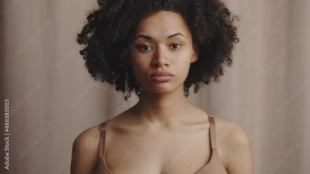 Natural beauty concept. Young confident beautiful curly african american lady rising head and looking at camera Natural beauty concept. Young confident beautiful curly african american lady rising head and looking at camera