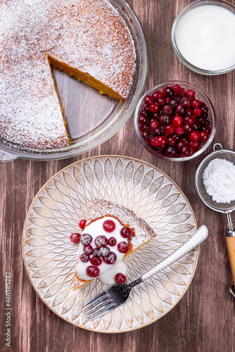 Piece of Swedish saffron Kladdkaka pie on a wooden plate, vertical, top photo