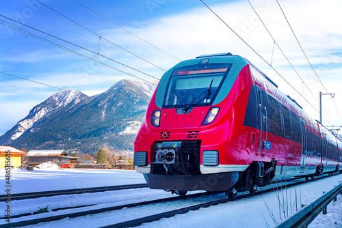 Zug fährt im Winter durch das verschneite Bayern