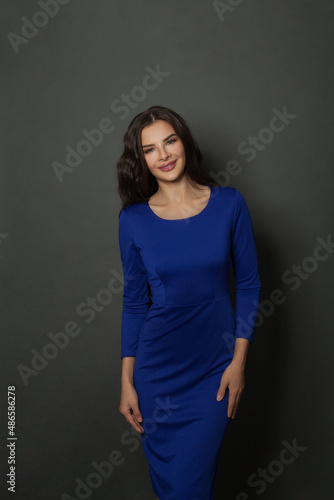 Attractive smiling woman studio shot on gray background.