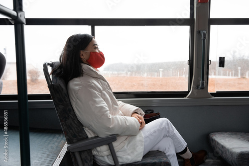 Asian woman in bus in autumn during pandemic photo