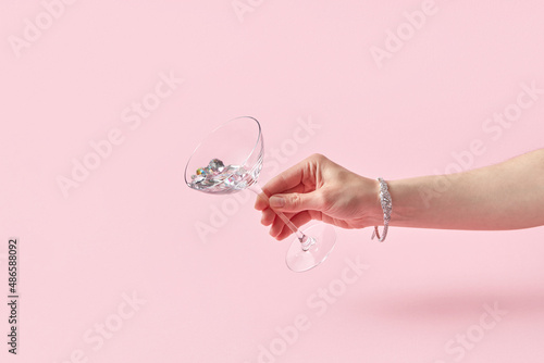 Woman holding glass with shiny gemstones photo