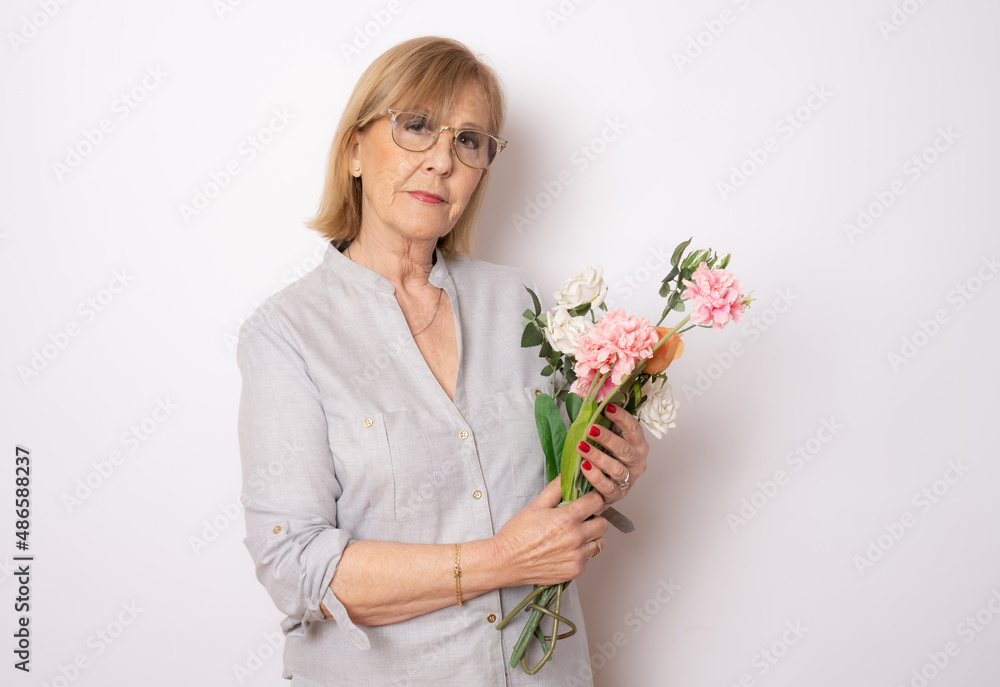 Happy senior woman with bouquet of flowers isolated over white background. Happy senior woman with bouquet of flowers isolated over white background.