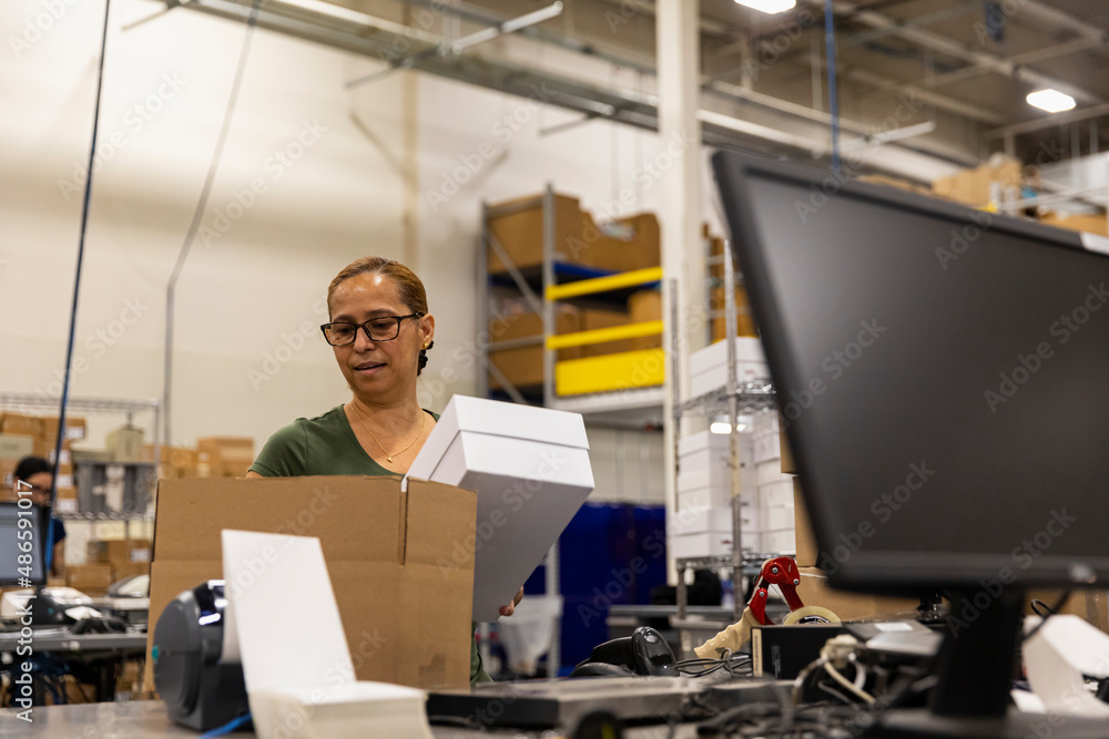 E-Commerce Worker packs white box for shipping E-Commerce Worker packs white box for shipping