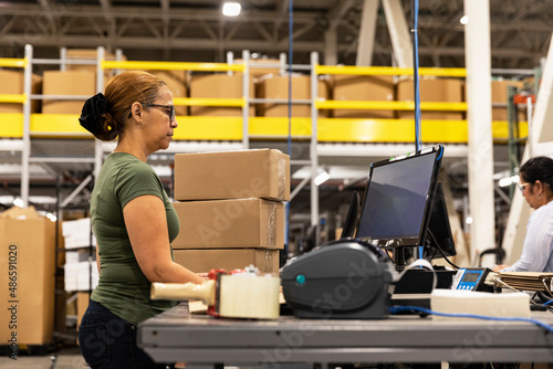 Employee enters data in computer at warehouse workstation