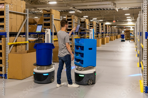 Employee Operating robot at ecommerce warehouse  photo