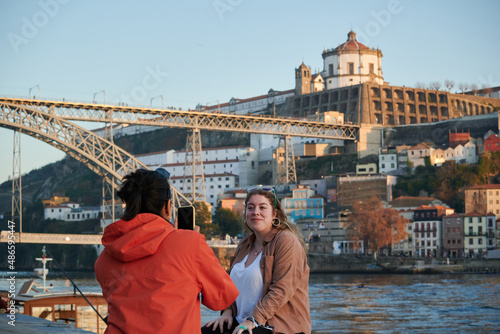 A woman taking a picture of her friend in Porto